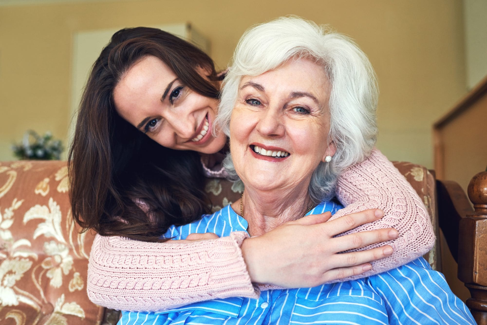 Assisted Living resident with granddaughter who is hugging her from behind