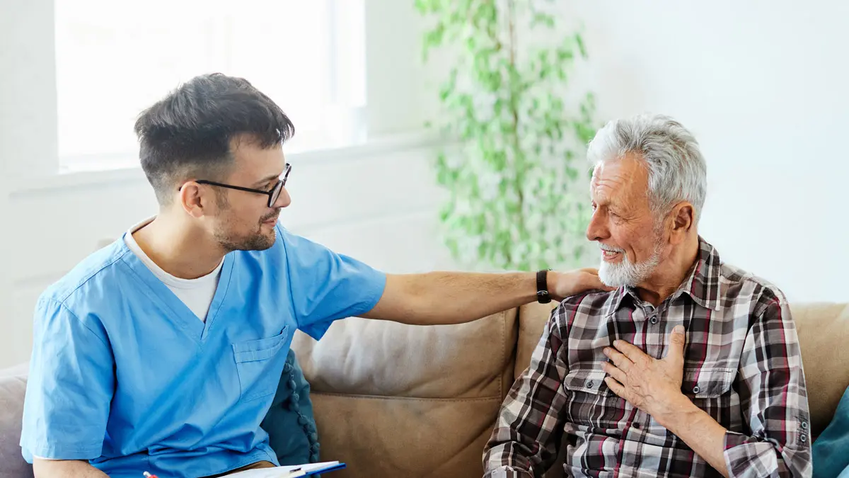 Care staff member reassuring a senior resident during a conversation at Charter Senior Living of Jackson in Jackson, TN