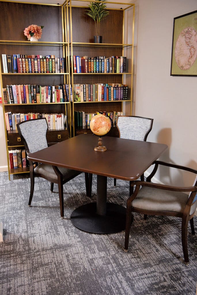 table and chairs next to bookcases full of books