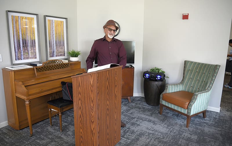 man at podium with piano