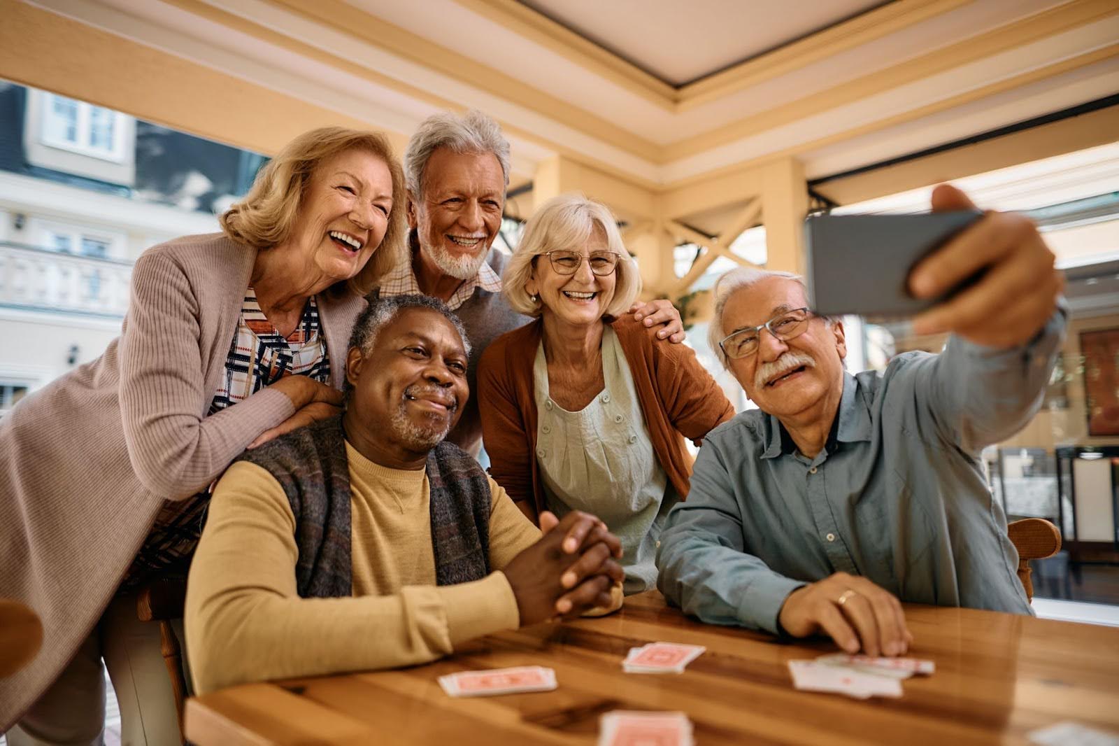 Residents taking a selfie and enjoying card games together at Charter Senior Living of Jackson in Jackson, TN